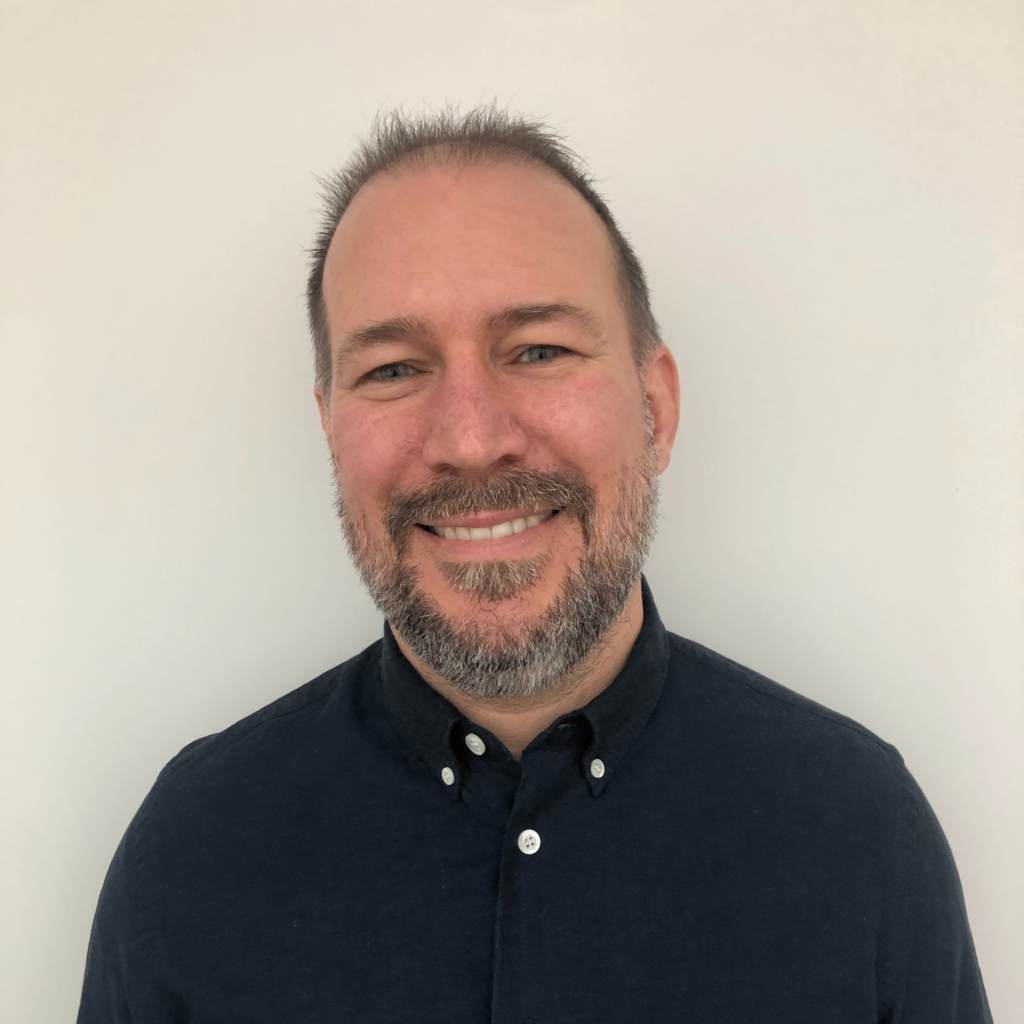 Pressbooks team member Hugh wearing a blue button up shirt