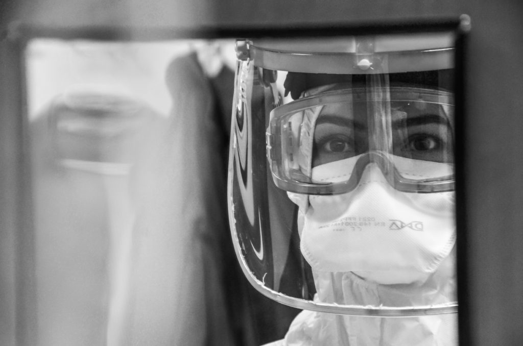 Black and white pohoto of a healthcare worker wearing protective gear