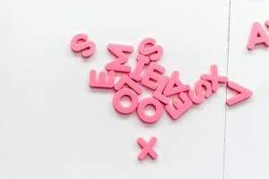 Scrambled pink letters against a white backdrop