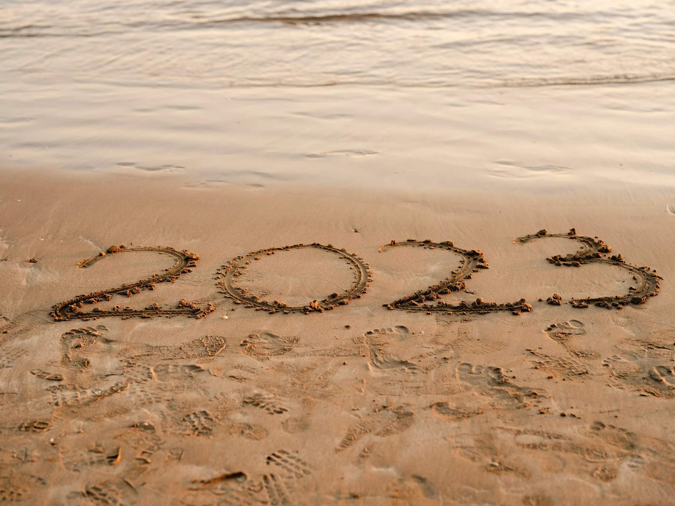 The year 2023 written in the sand