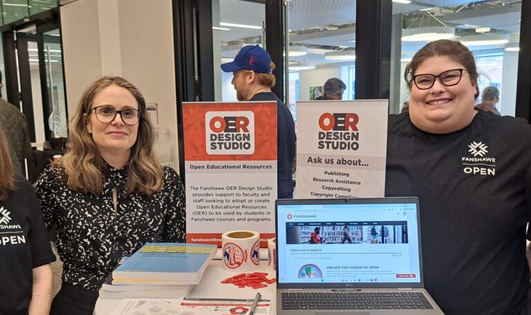 members of the Fanshawe OER design studio at a conference table with laptop and signane
