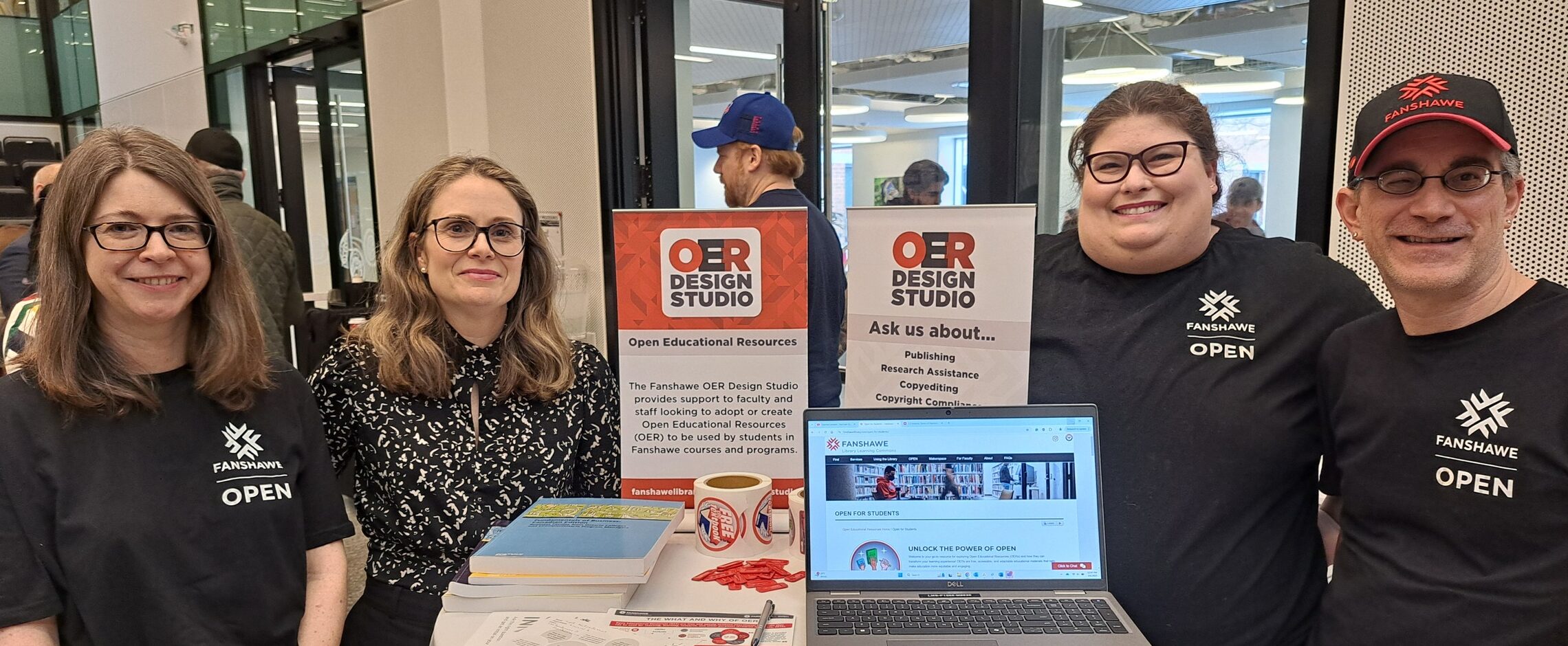members of the Fanshawe OER design studio at a conference table with laptop and signane